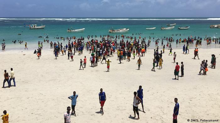 Crowds in the foreground and boats in the water at Liido beach (DW/S. Petersmann)