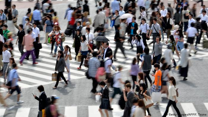 Pedestres atravessam avenida em Tóquio