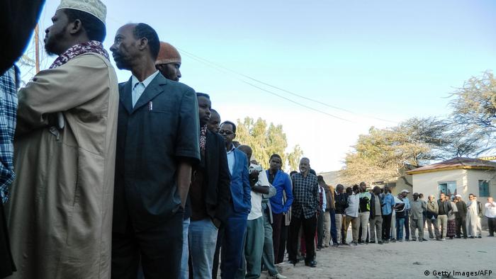 Men queue at a polling station (Getty Images/AFP)