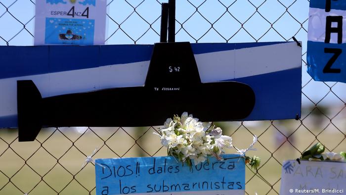 Цветы и макет подлодки на ограде базы ВМС Аргентины