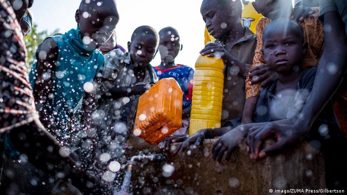 Children fight to fill up water bottles at a water point