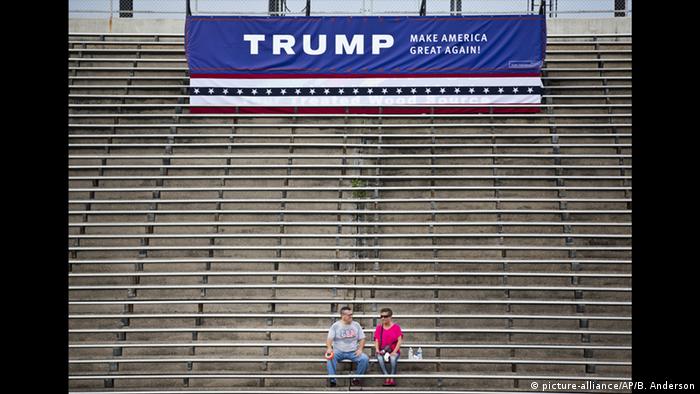 Two people sitting before a Trump rally