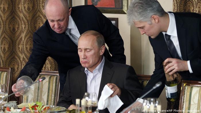 Евгений Пригожин (вляво от Путин) обслужва руския президент