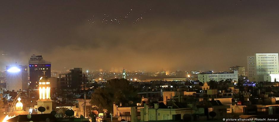 Fogo dos bombardeios ocidentais ilunina céu de Damasco