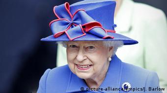 Queen Elizabeth II wears a blue outfit with red-trimmed bow on her blue hat (picture-alliance/empics/J. Barlow)