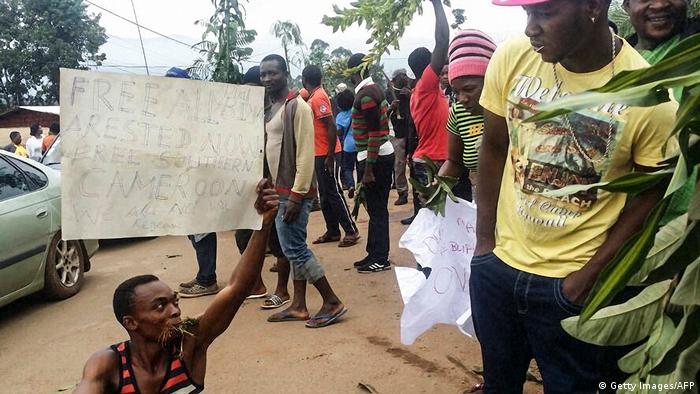 A demonstrator in Cameroon carries a sign calling for the liberation of detained activists (Getty Images/AFP)