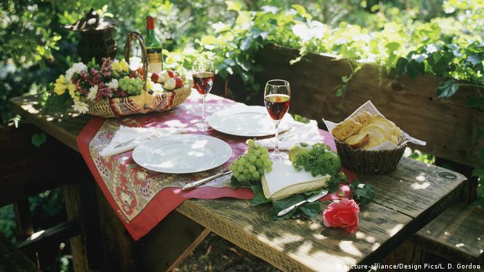 Mesa decorada con vino, uvas, queso y pan.