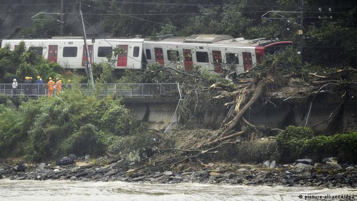 A landslide buried a railway track under mud and trees while knocking a train off the rails.