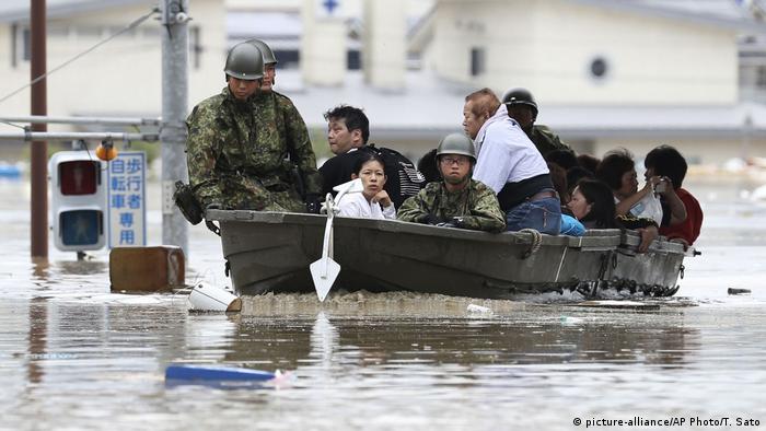 Japanese soldiers evacuate stranded residents in Kurashiki by boat.