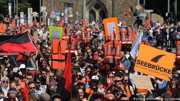 Protesters hold up life jackets and signs at a protest in Berlin to support migrant rescue operations in the Mediterranean Sea (picture-alliance/dpa/J. Carstensen)