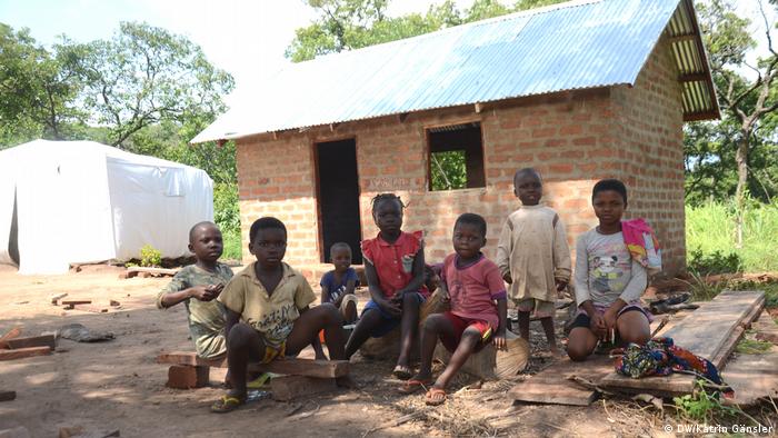 Cameroonian displaced children sitting before a half-built brick hut(DW/Katrin Gänsler)