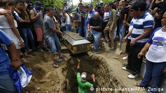 Familiares de un joven asesinado en el marco de las protestas contra el gobierno de Daniel Ortega presencian su sepelio.
