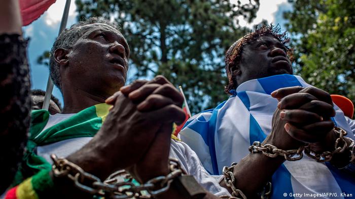 Two men in chains protest against the slave trade in Libya (Getty Images/AFP/G. Khan)