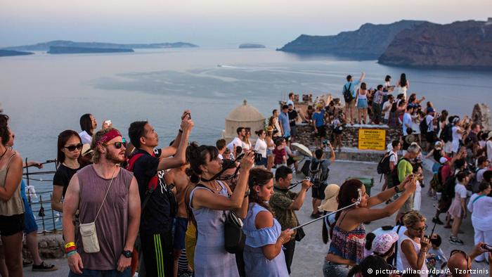 Tourists in Greece watch sunset (picture-alliance/dpa/A. Tzortzinis)