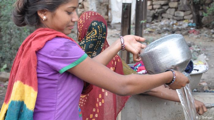 A woman fills up vessels at the water fountain (Source: Jasvinder Sehgal)