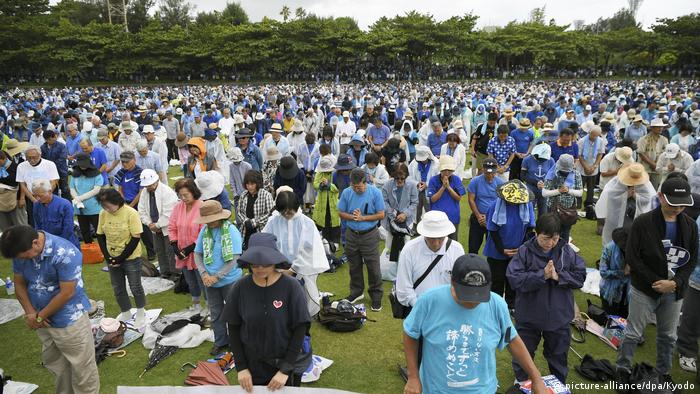 Protesters in Okinawa bow their heads in rememberance of their late-governor.