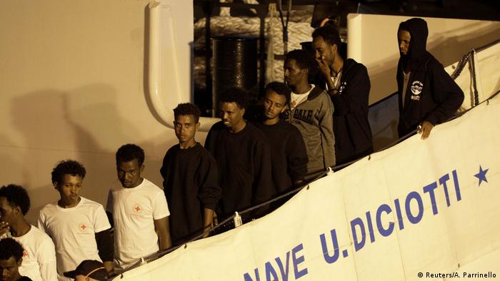 A stream of migrants disembark from the Diciotti, an Italian coast guard boat.