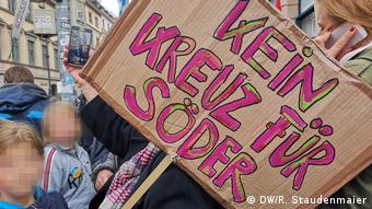 A protester holds up a sign reading: No cross (vote) for Söder) at a demonstration in Munich, Germany (DW/R. Staudenmaier)
