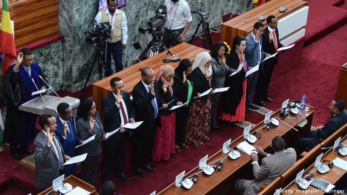 Members of Ethiopia's new cabinet raise their hands as they take their oath of office at the parliament