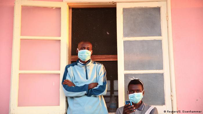 Tuberculosis patients, wearing masks to stop the spread of the disease, stand outside a hospital in Angola (Reuters/S. Eisenhammer)