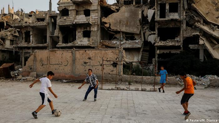 Em Damasco, crianÃ§as jogam futebol em meio a escombros causados pela guerra civil na SÃ­ria