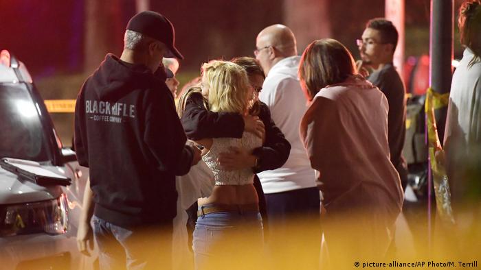 People comfort each other as they stand near the scene Thursday, Nov. 8, 2018, in Thousand Oaks, Calif