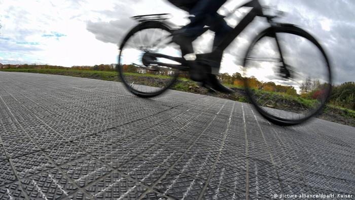 Bicicleta corre sobre malha de pastilhas fotovoltaicas que cobre ciclovia 
