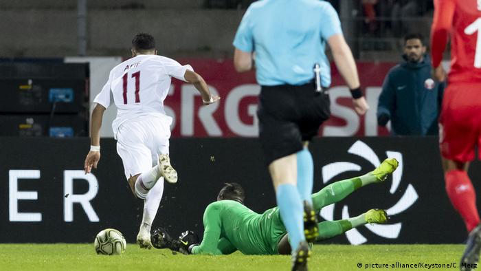 O atacante Akram Afif dribla o goleiro Yvon Mvogo para marcar o gol da vitória do Catar contra a Suíça