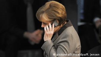 Ангела Меркель говорит по сотовому телефону