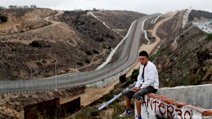 Foto de un migrante de Honduras frente al muro entre EE. UU. y México