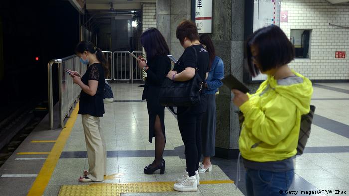 China Peking - Menschen starren auf ihr Handy wÃ¤hrend Sie auf den Zug warten (Getty Images/AFP/W. Zhao)