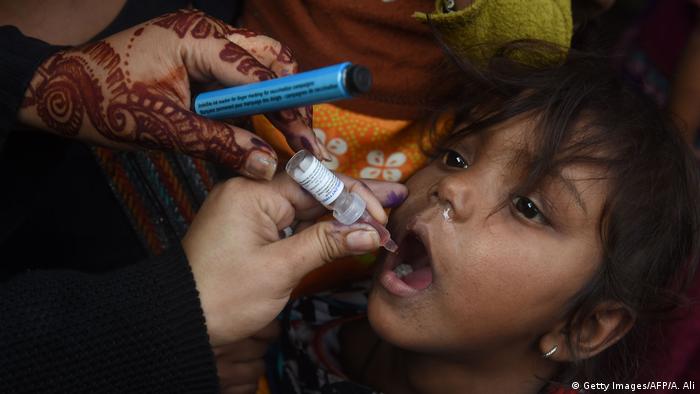 A Pakistani health worker administers polio vaccine drops to a child during a polio vaccination campaign in Lahore (Getty Images/AFP/A. Ali)