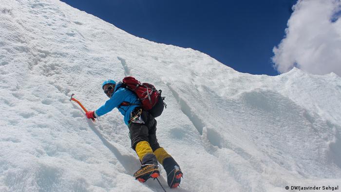 Un hombre escalando una montaña helada.