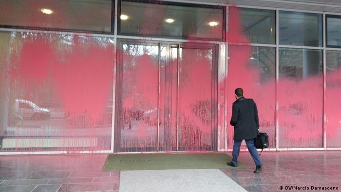 Tinta rosa cobre fachada da embaixada brasileira e homem com maleta caminha para entrar no prédio