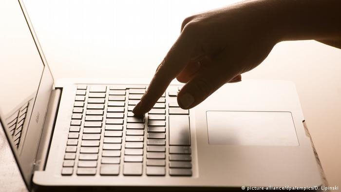 Человек работает за персональным компьютером - рука на клавиатуре