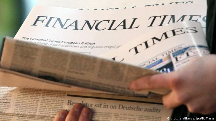Человек берет в руки газету Financial Times