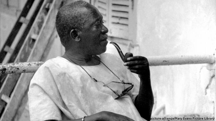 Film director Ousmane Sembene holding a pipe in his hand(picture-alliance/Mary Evans Picture Library)