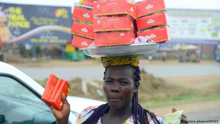 A woman vendor in a street of Accra carrying her wares on her head