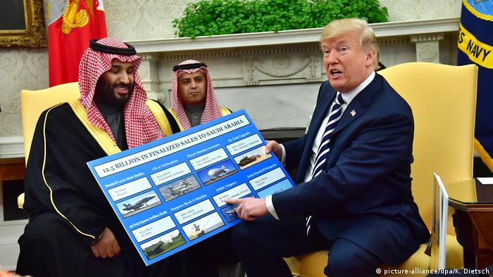US President Donald Trump points to a picture of the weapons systems the US has just sold to Saudi Crown Prince Mohammed bin Salman, sitting next to him.