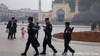 In this Nov. 4, 2017 file photo, Uighur security personnel patrol near the Id Kah Mosque in Kashgar in western China's Xinjiang region. 