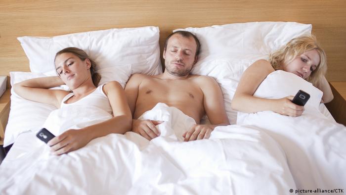 Mann mit zwei Frauen in einem Hotelbett (picture-alliance/CTK)