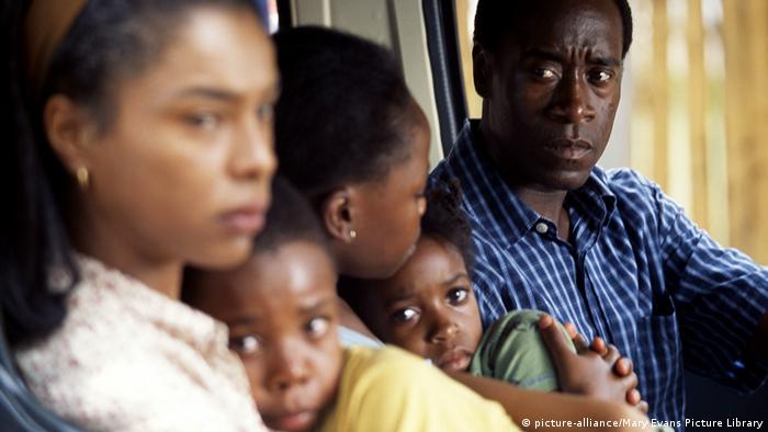 Film still from Hotel Rwanda: A man sitting with two women and two scared children in a car (picture-alliance/Mary Evans Picture Library)