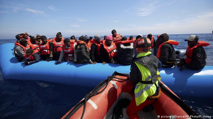 Migrants sitting in a boat on the Mediterranean Sea (picture-alliance/AP Photo/F. Heinz)