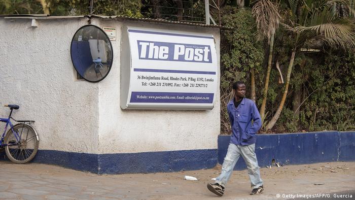 A man in Lusaka walks past the now-closed headquarters of The Post