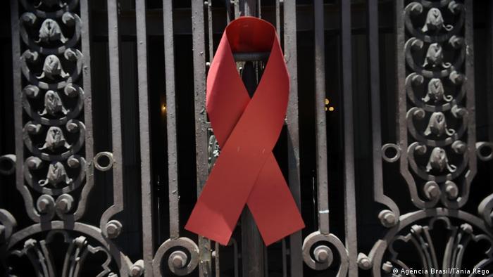 Laço vermelho do combate à aids pregado em portão de ferro
