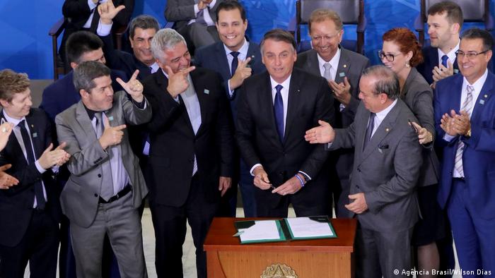 Bolsonaro ao lado de parlamentares durante assinatura de decreto sobre porte de armas em maio de 2019