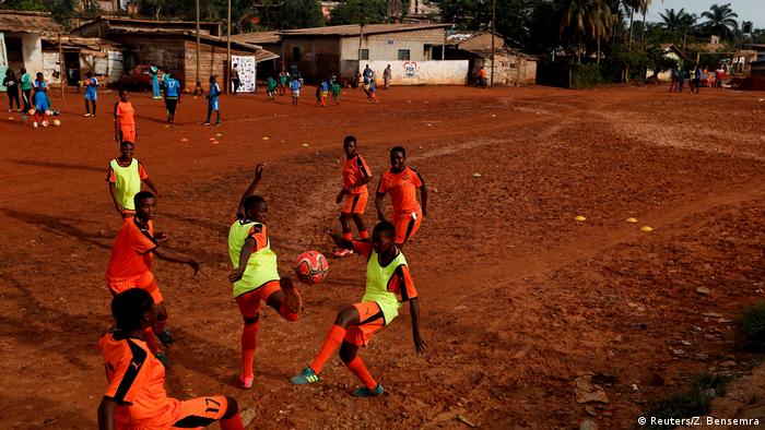 Girls playing football on a read earth football pitch (Reuters/Z. Bensemra)