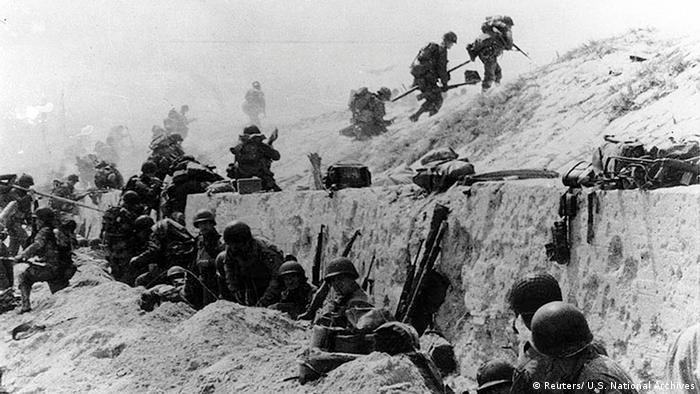 Soldados americanos escalam uma muralha de concreto na Praia de Utah, na Normandia, em 6 de junho de 1944