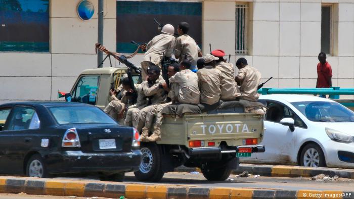 Soldiers sit on the back of a military car (Getty Images/AFP)
