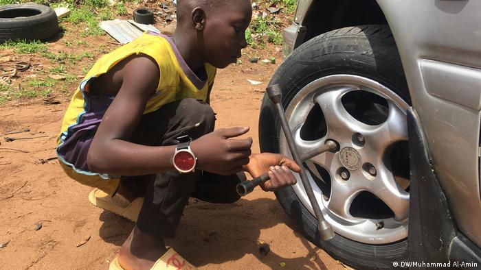 A boy changing a tire (DW/Muhammad Al-Amin)